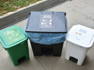 Lixeira verde, preta e branca utilizadas para separação de resíduos orgânicos, recicláveis e rejeitos, respectivamente.