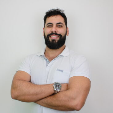 homem branco, com cabelos e barba preta, sorrindo