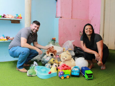 dois adultos ao lado de brinquedos
