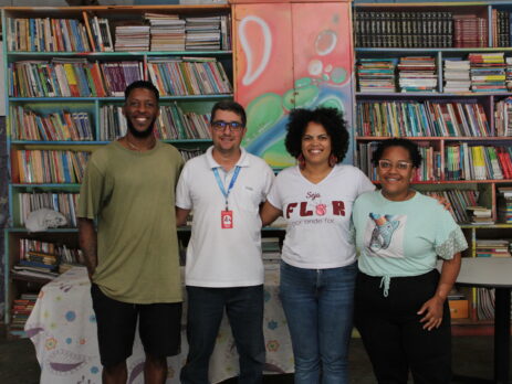 grupo de pessoas em frente a uma grande estante de livros
