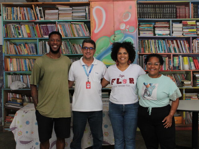 grupo de pessoas em frente a uma grande estante de livros